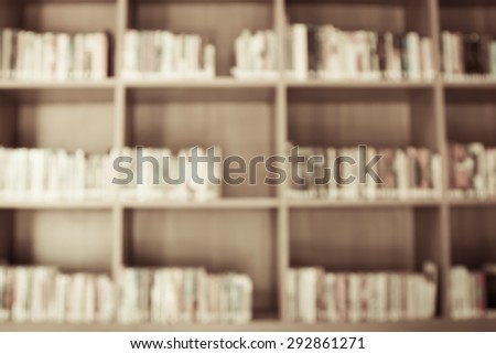 Blurred books on the shelf in public library in vintage color tone for background
