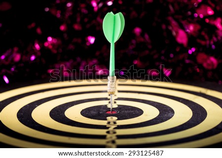 Success hitting target aim goal achievement. Dart in target center on dartboard, vintage effect filter