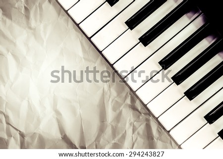 top view of black and white piano keys with  wrinkled paper filter in vintage color tone,music concept