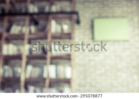 Blurred books on the shelf with brick wall in public library in vintage color tone