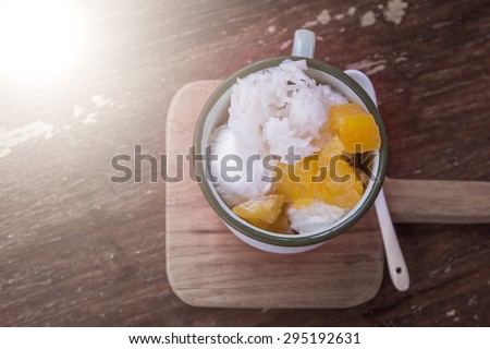 coconut milk ice cream with sticky rice and yam in old glass on wooden table in vintage color tone,Thailand dessert