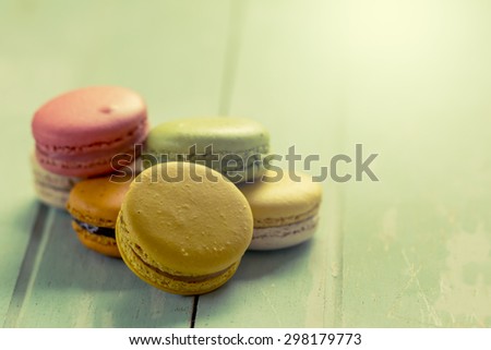 Sweet and colorful french macaroons on wooden table in vintage color tone
