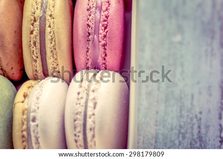 Sweet and colorful french macaroons on wooden table in vintage color tone
