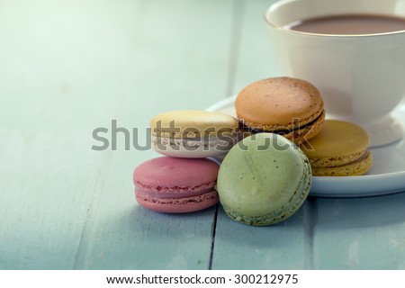 Sweet and colorful french macaroons with coffee cup in vintage color tone