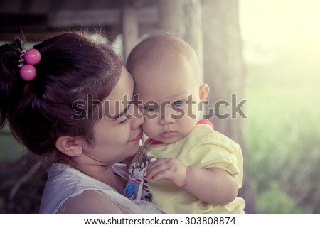 Mother kiss cute little boy with love in sweet soft color filter