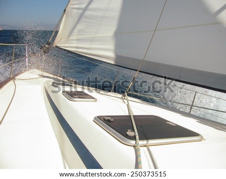 rigging parts and spray with a wave of a small sea yacht