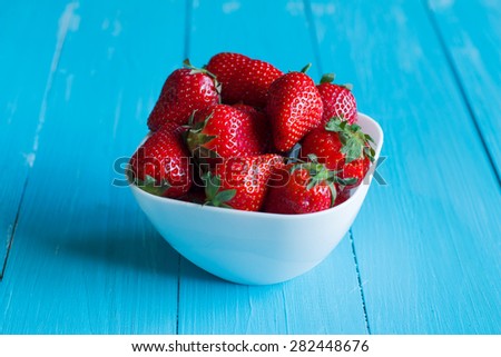 Plate of strawberries on a wooden table. Delicious breakfast.