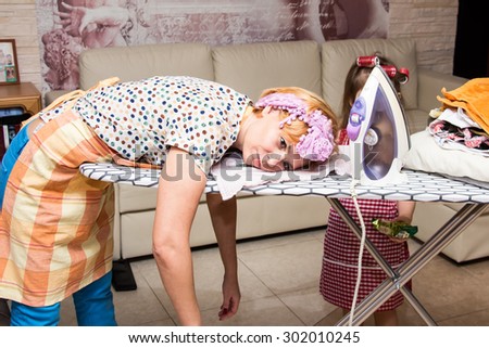 Woman tired ironed clothes and lay down on the ironing board