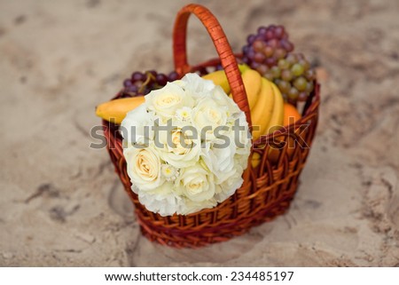 Pastel wedding bouquet in wooden basket with fruits. Selective focus