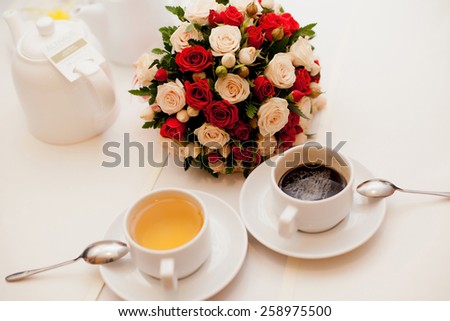 Close up of wedding bouquet with a cup of tea and coffee