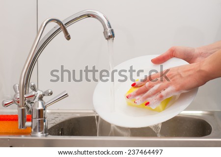 housewife with  nice manicure washes dishes