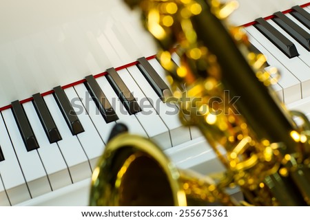 on the foreground of sax shining on the background a white grand piano