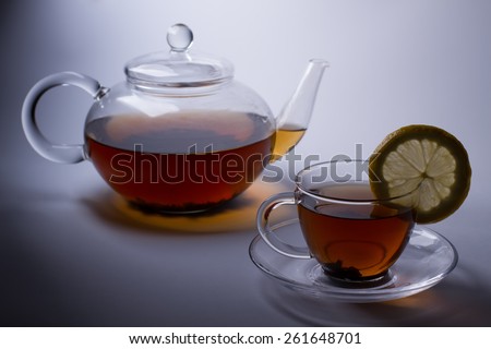Silhouette of glass tea set with black tea and lemon.