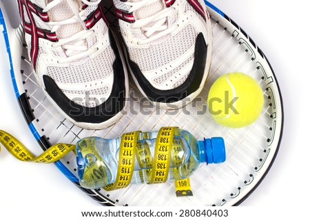 Set for tennis.Men\'s running shoes on a tennis racket.