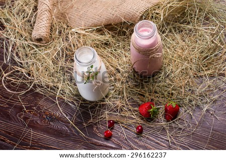 Strawberry milkshake on the background of hay.Natural rural milk.