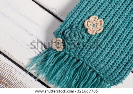 Detail of handmade knitted scarf.Wool scarf on a wooden background.