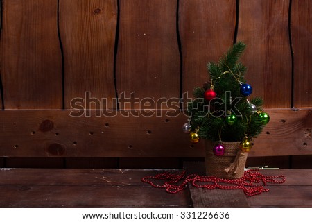 Christmas tree on the background of a wooden fence. Good New Year spirit.