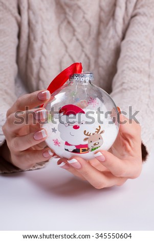 Beautiful Christmas glass ball. Christmas toy in the hands of women. Merry Christmas and Happy New Year.