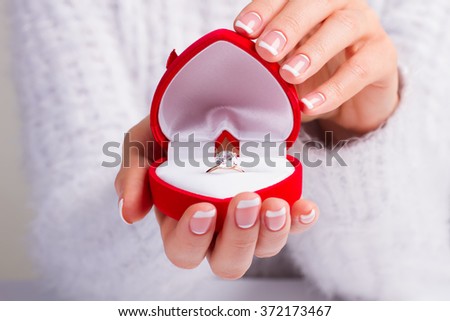 Girl holding a box with a diamond ring. Beautiful manicure. Proposal for married.
