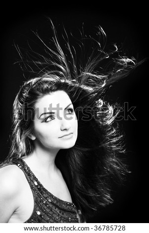 A black and white image of a beautiful young woman with flowing hair. Film noir style.