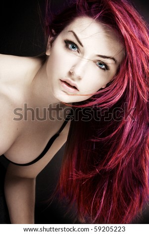 stock photo A woman with magenta hair looking at the camera in front of a