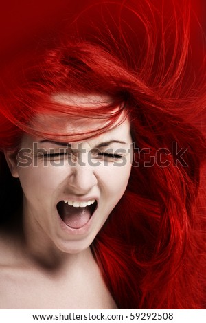 A furious young woman with her hair red like fire.
