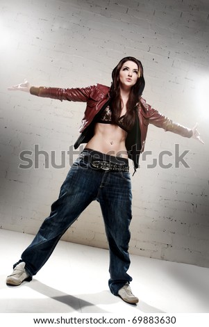 A ghetto styled girl posing in front of brick wall