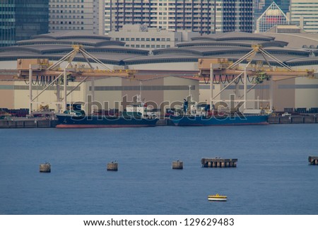 Medium sized cargo transport ships unloading at the wharf.