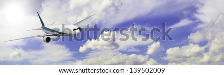Modern 2 engine airliner banner on a mainly cloudy sky.