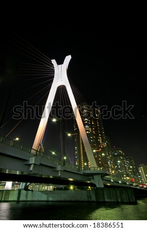 A modern suspension bridge spanning the river at night time