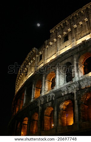 The colosseum with the moon showing over the wall at night