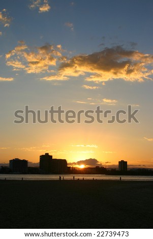 The sunsets over the beautiful river with people and building silhouettes