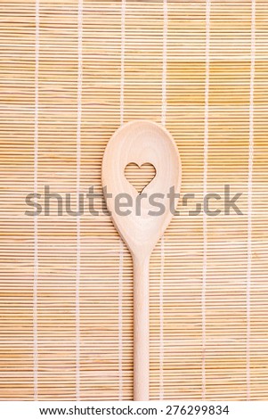 Wooden spoons with heart motif on bamboo serving backgrounds. Wooden kitchen spoon.