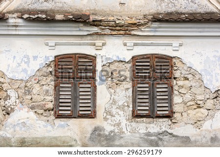 Classic jalousie windows in old house wall. Old house windows.