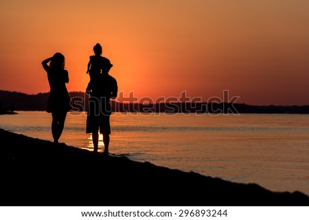 Happy Young Family who Taking Photos on the Beach at Sunset. Young Family Silhouette.