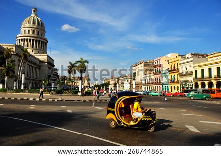 HAVANA, CUBA - DECEMBER 15 2014: Moto taxi in the center of Havana with the Capitolio as background. The US has announced changes to its policy with Cuba