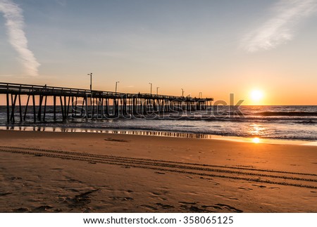 Virginia Beach, Virginia boardwalk fishing pier and beach at dawn.