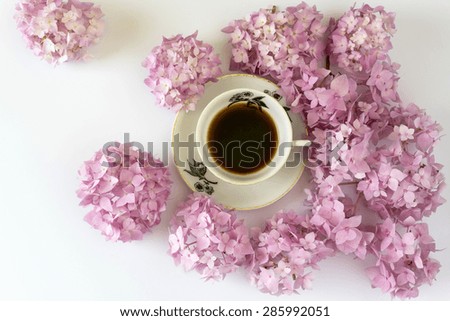 cup of coffee on white background with flowers, cup of coffee on white background with  pink flowers, romantic moment, natural light, view from above
