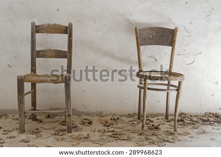 old wooden chairs on white background,dust and cobwebs on the chairs natural light, front view