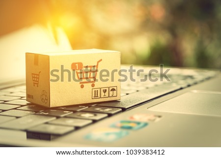Online shopping and ecommerce via internet concept : One paper box with shopping cart logo on a laptop computer, depicts consumer always buys personal goods or things directly from online retail store