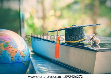 Graduate study abroad program for opening or expand world view concept Graduation cap or hat, world globe map and foreign book on a laptop, depicts an achievement or success in long distant learning