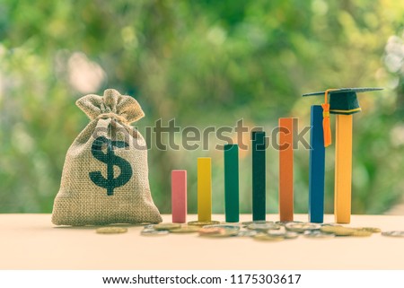 Education or student loan, financial aid and scholarship concept : US dollar cash bag, coins, a black graduation cap or hat / mortarboard on rising wood pole, depict the increasing cost of tuition fee