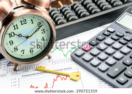 Golden key with a clock, a calculator and an abacus over business and financial summary reports. Key success in sustainable growth investment concept.