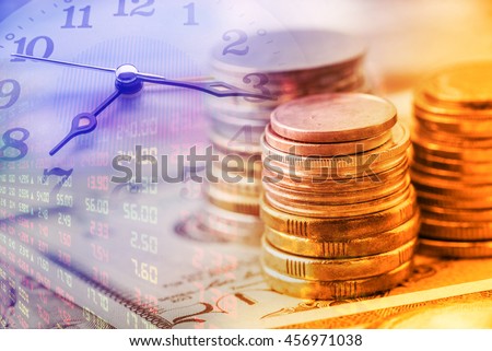 Closeup view : Stack of coins and clock hands. A concept / idea of time value of money. Money at present time is worth more than the same amount in the future due to its potential earning capacity.