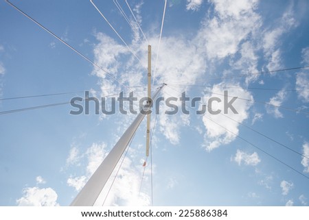 yacht mast with stretch marks and blue sky, bright sun