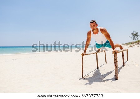 fitness handsome man work out on the beach with sea view