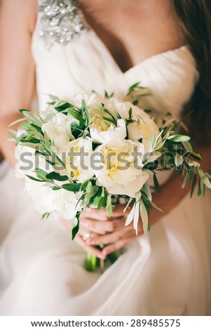 bride holding wedding bouquet white peony close up in fine art style
