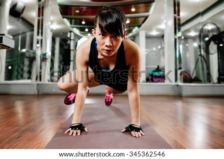 asian fitness girl instructor stretching and shaping in gym