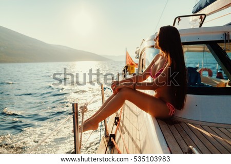 luxury woman yachting in sea at sunset. Sea waves background.