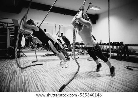 crossfit group training. Man and woman group training indoors. Black and white